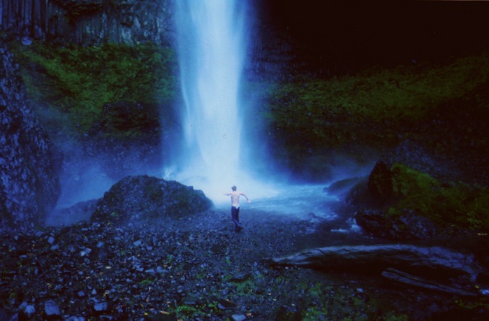 Hombre bañandose debajo de una cascada