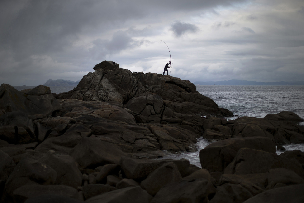 A man casts his fishing rod to the Atlantic sea at the coast of Baiona, Pontevedra province, northern Spain, Sunday, June 9, 2013. (AP Photo/Daniel Ochoa de Olza)