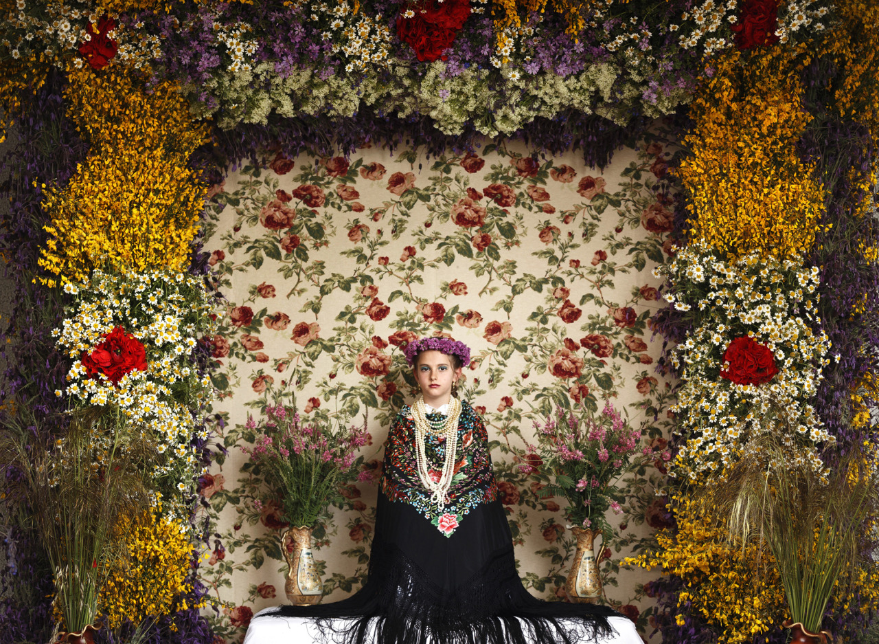 EDS NOTE - SPANISH LAW REQUIRES THAT THE FACES OF MINORS ARE MASKED IN PUBLICATIONS WITHIN SPAIN - A 'Maya' girl sits in an altar during the traditional celebration of 'Las Mayas' on the streets in Colmenar Viejo, near Madrid, Spain, May 2, 2015. The festivity of the Maya comes from pagan rites and dates from the medieval age, appearing in ancient documents, it takes place every year in the beginning of May and celebrates the beginning off the spring. A girl between 7 and 11years is chosen as 'Maya' and should sit still, serious, and quiet for a couple of hours in an altar on the street decorated with flowers and plants, afterwards they walk to the church with their family where they attend a ceremony. (AP Photo/Daniel Ochoa de Olza)
