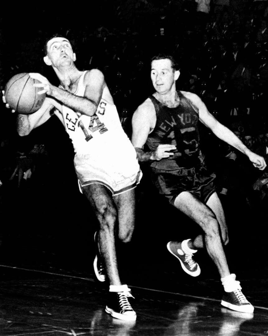 BOSTON, MA - 1950: Bob Cousy #14 of the Boston Celtics drives to the basket against Dick McGuire #15 of the New York Knicks at the Boston Garden circa 1950 in Boston, Massachusetts. NOTE TO USER: User expressly acknowledges that, by downloading and or using this photograph, User is consenting to the terms and conditions of the Getty Images License agreement. Mandatory Copyright Notice: Copyright 1950 NBAE (Photo by: NBA Photo Library/NBAE via Getty Images)