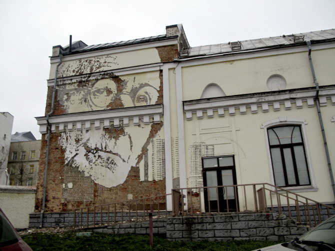 arte callejero esculpiendo en la pared, anciana con gafas