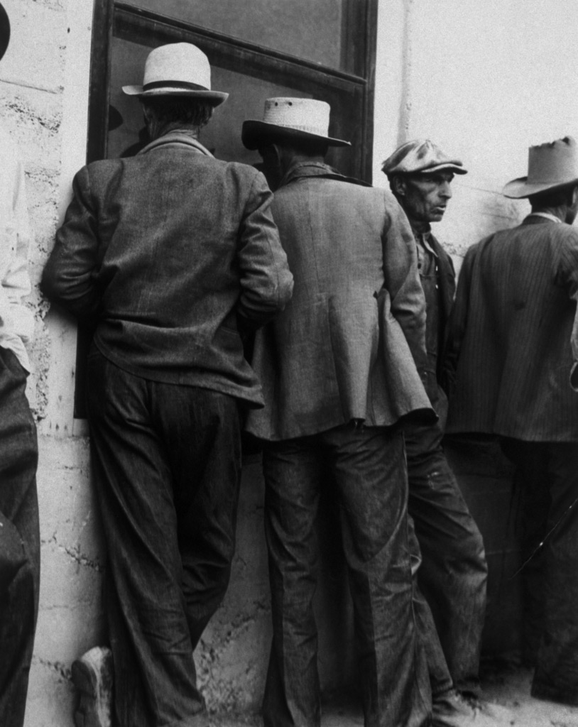 Fotografia en blanco y negro de Hombres en los años 60 haciendo cola