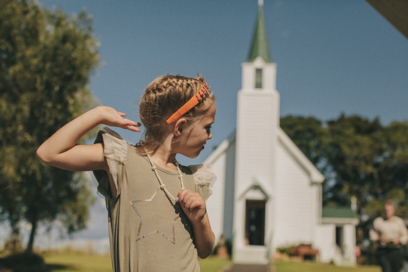 NIÑA FRENTE UNA IGLESIA