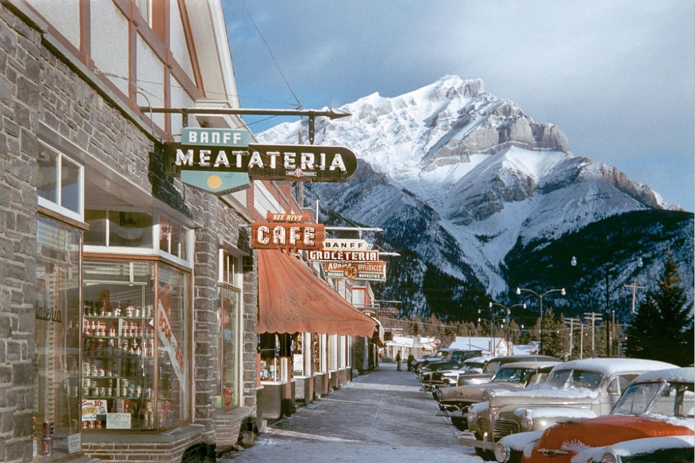 Fotografía de una montaña nevada desde una calle nevada por Fred Herzog
