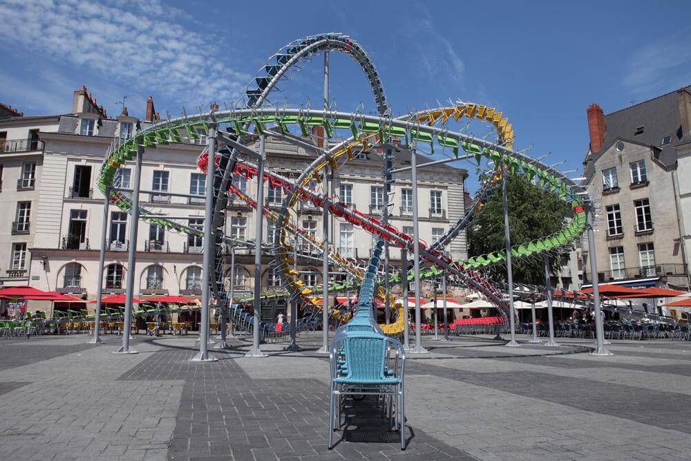montaña rusa hecha con sillas de cafeterias a modo de escultura