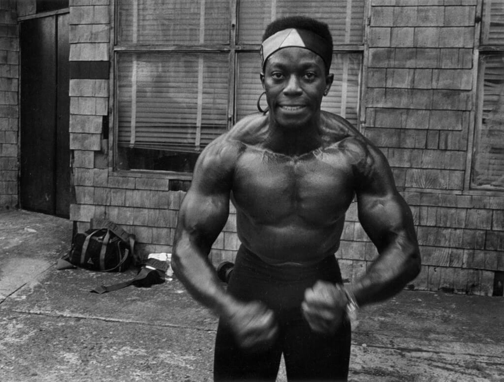 persona de color sin camiseta posando en una calle de harlem