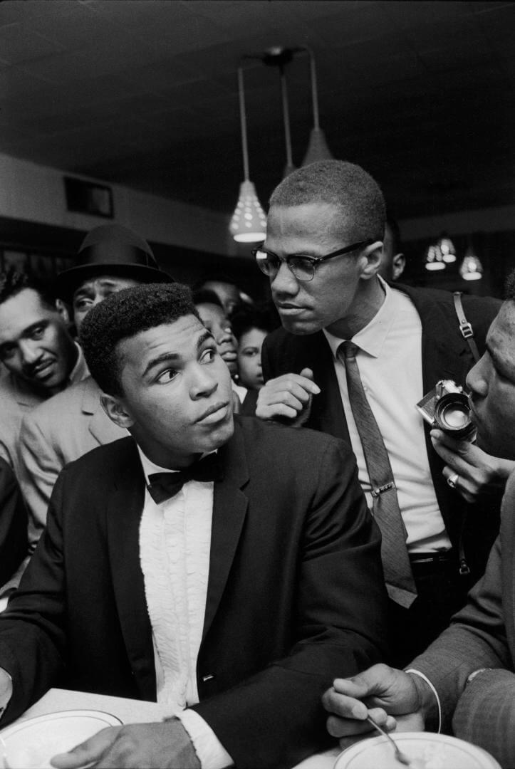 Mohamed ali junto un fotografo en una rueda de prensa