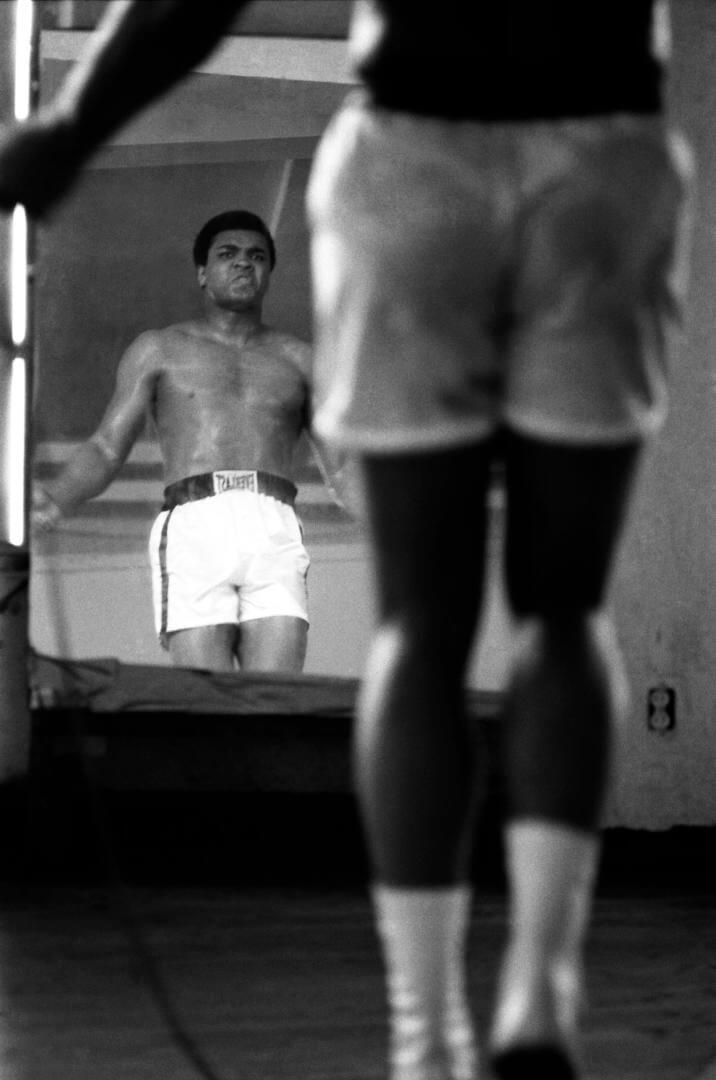 Boxeador Mohamed ali saltando a la comba frente al espejo