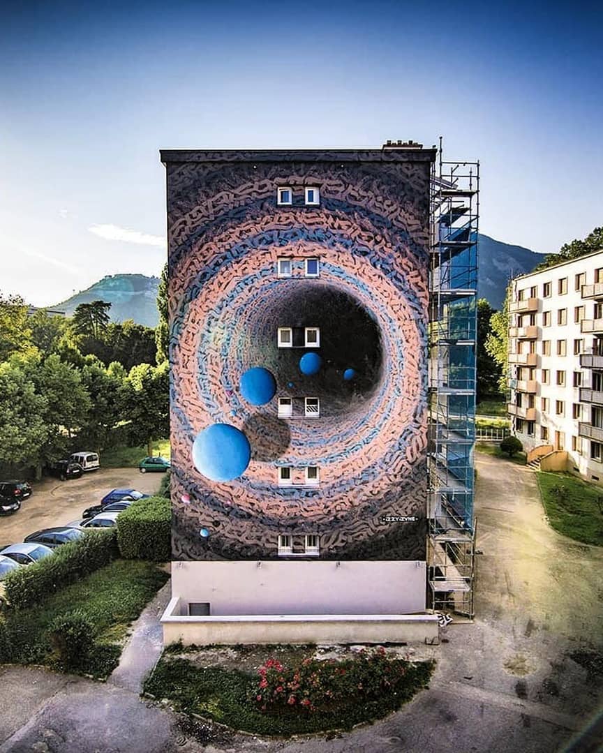mural gigante con planetas y letras de Izzi-Izvne