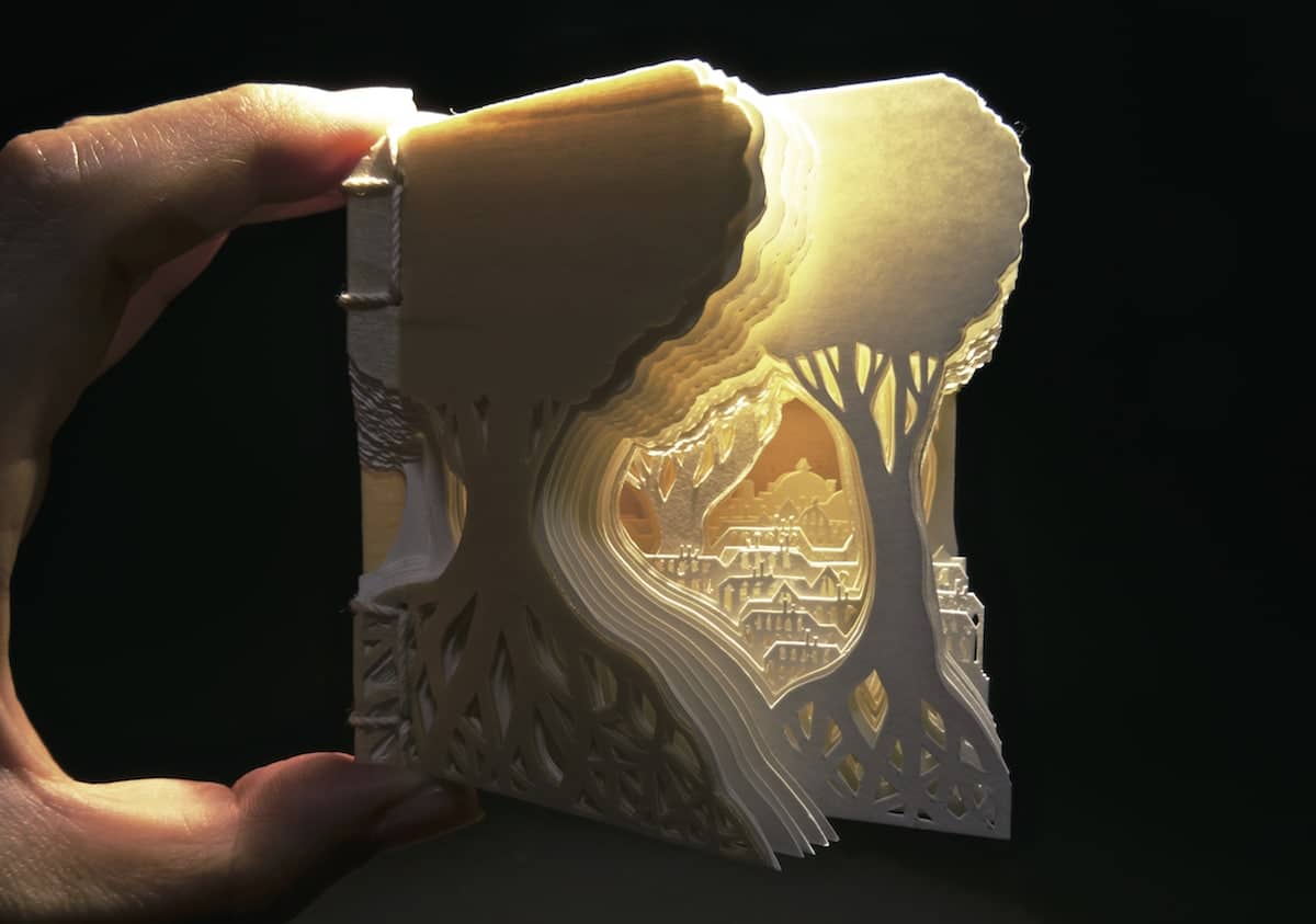 Libro diminuto hehco a base de papel recortado por la arista japonesa ayumi shibata