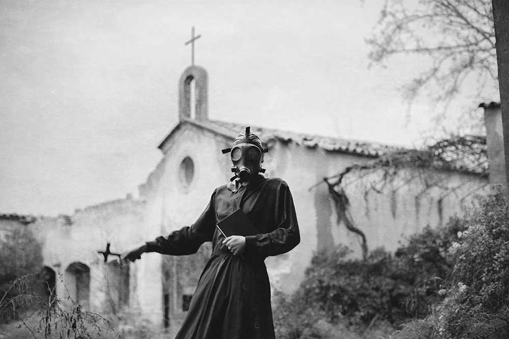 fotografía de mujer con mascara de gas frente una iglesia