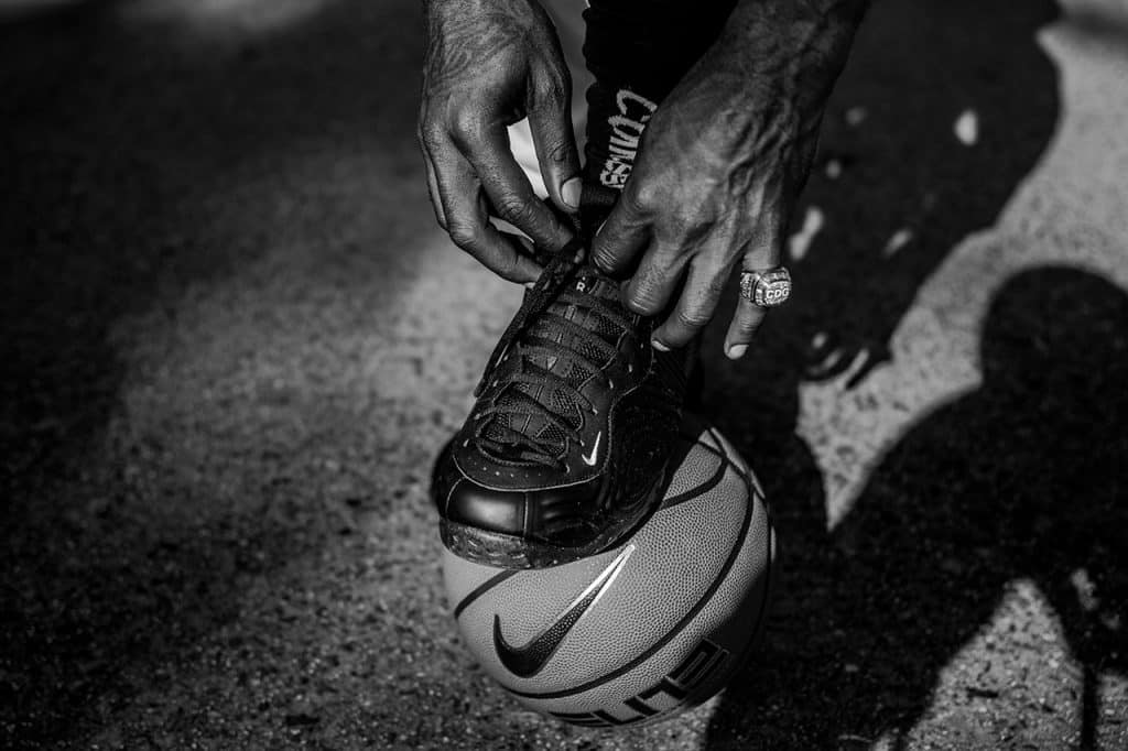Primer plano de hombre de color atandose unas zapatillas nike