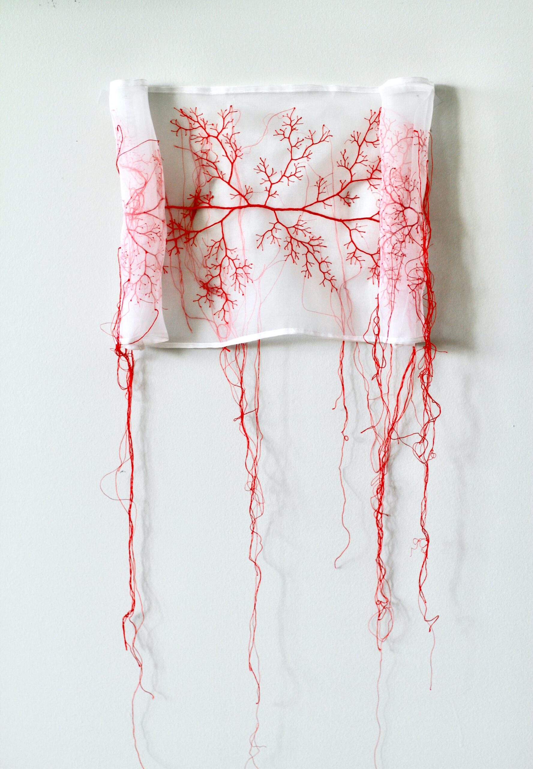 papeles de tela translucida bordados con hilo rojo que representan la biena suerte en japon por la artista rima day