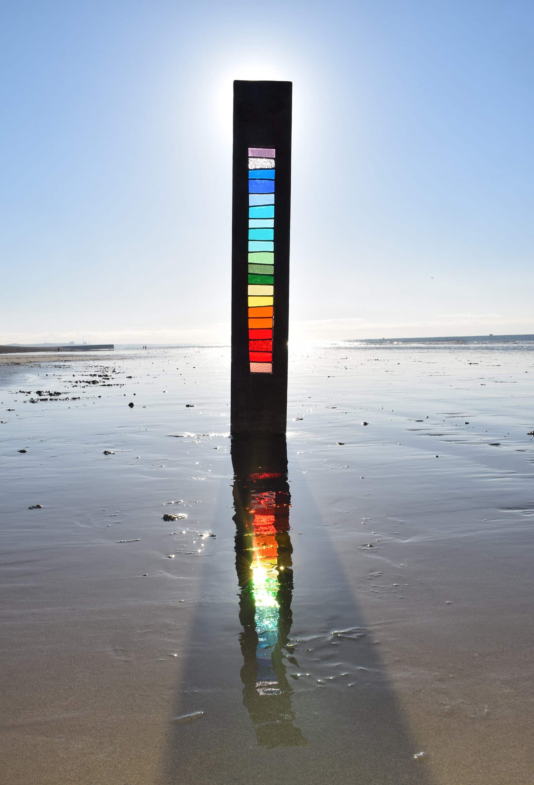 vidrio en colores de arcoiris y madera en el mar con luz de atardecer