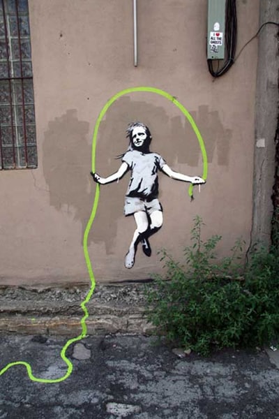 Niña saltando un cable de banksy