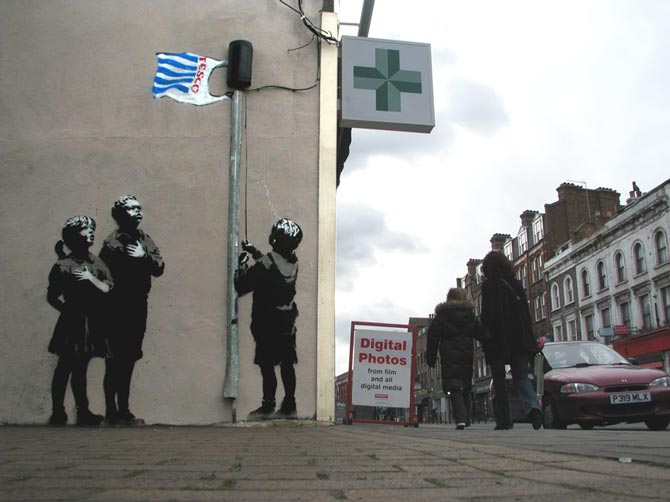 Niños subiendo bolsa bandera de tesco street art de banksy